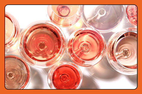 Overhead shot of wine glasses filled with red and rose wines of varying shades and depth of color.